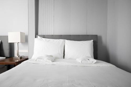a white bed with two towels on top of it at 4th St Little Blue in Bham in Graymont