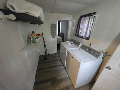 a laundry room with a washing machine and a washer at 4th St Little Blue in Bham in Graymont