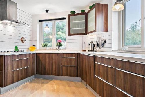 una grande cucina con armadi in legno e finestre di 40711-Ulfborg-Hagevej-148 a Fjand Gårde