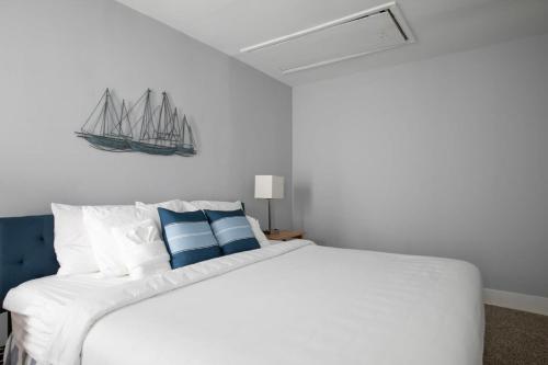 a bedroom with a white bed with blue and white pillows at 4th St Little Blue in Bham in Graymont