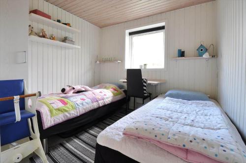 a small bedroom with a bed and a desk at 30401-Ulfborg-Klovervej-469 in Vang