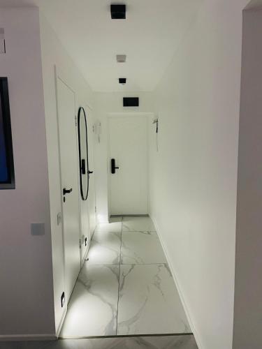 a hallway with white walls and a white door at White Apartment in Liepāja