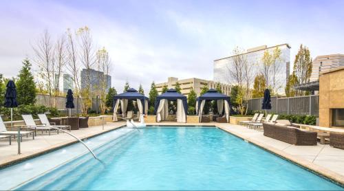 a pool at a hotel with chairs and umbrellas at The Stay 1 - Tysons Corner in Howard