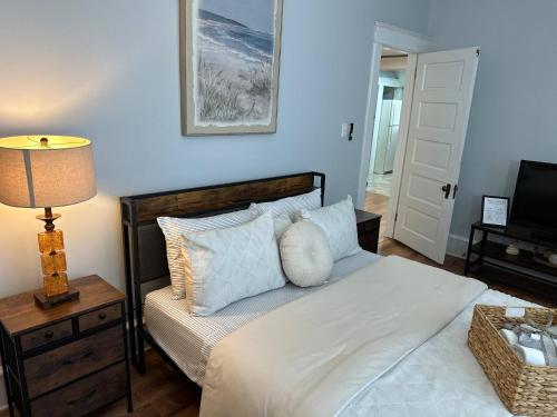 a bedroom with a bed with a lamp and a television at Cozy 2-BR Retreat Private Parking Near Downtown in Wilmington