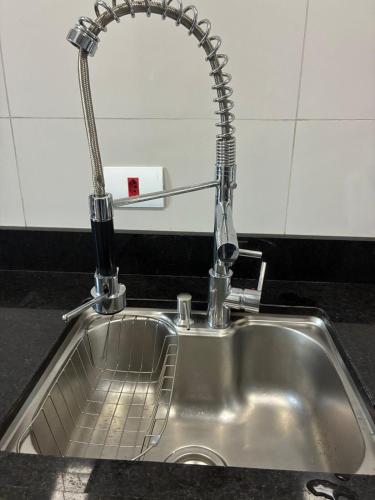 - un évier en acier inoxydable avec un robinet dans la cuisine dans l'établissement Casa em foz do iguaçu, à Foz do Iguaçu