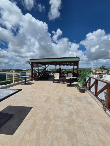 a patio with a gazebo and chairs on a deck at Costa Love Hotel Aeropuerto in Punta Cana