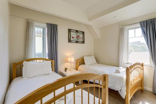 two beds in a room with two windows at Walk to Dimond District Gems Home in Oakland in Oakland
