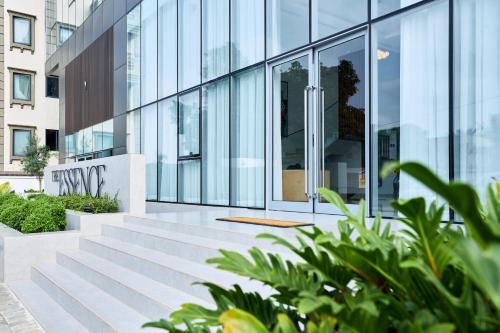 a glass building with stairs in front of it at A Tranquil Studio in Airport Residential with Pool - The Essence in Accra