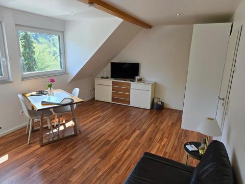 a living room with a table and a tv at Ferienwohnung "Zum Klosterruinenblick" in Kröv