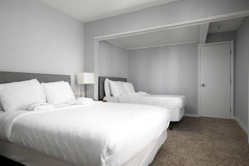 two beds in a hotel room with white sheets at 4th St Little Blue in Bham in Graymont