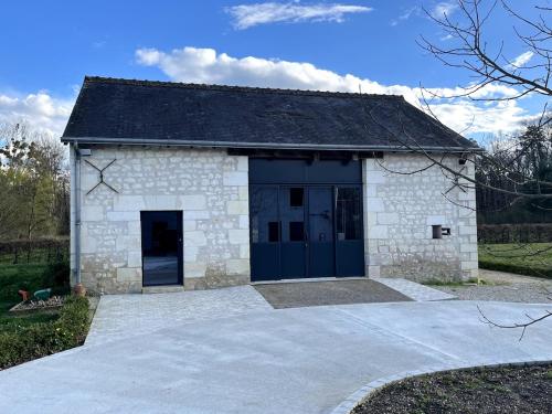 a large stone building with a large garage at La Ruche Enchantée in Champigny-sur-Veude