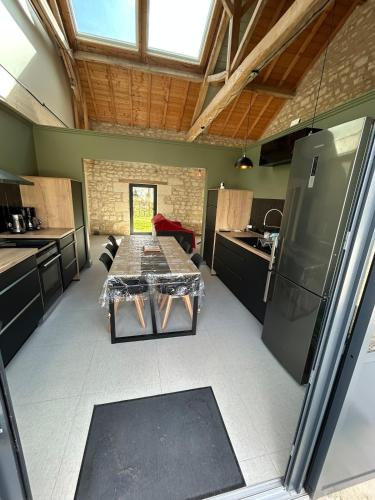 a kitchen with a table in the middle of a room at La Ruche Enchantée in Champigny-sur-Veude