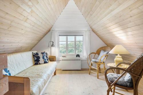 a attic room with a couch and a window at 10732-Ulfborg-Svollingvej-94 in Ulfborg