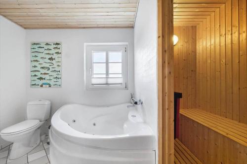 a white bathroom with a tub and a toilet at 10732-Ulfborg-Svollingvej-94 in Ulfborg