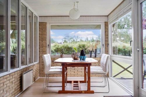 a screened in porch with a table and chairs at 30073-Ulfborg-Grastensborgvej-35 in Sønder Nissum