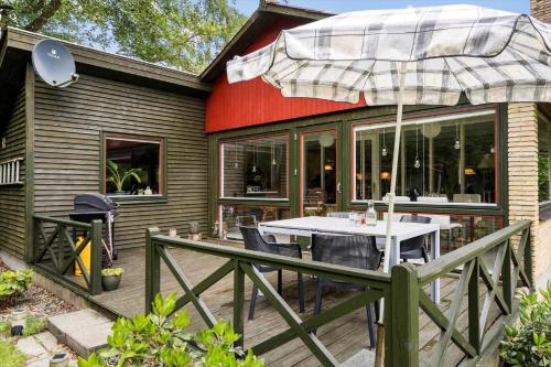 a patio with a table and an umbrella at 30073-Ulfborg-Grastensborgvej-35 in Sønder Nissum