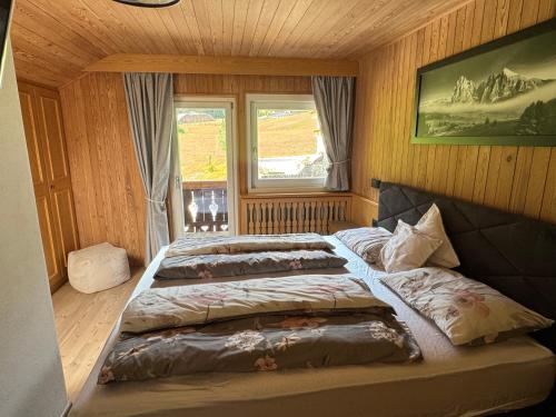 een slaapkamer met twee bedden en een raam bij Appartamenti Hacoli in Selva di Val Gardena