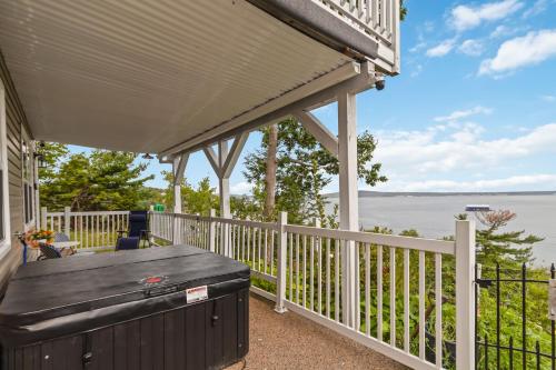 a porch with a large deck with a view of the water at Entire Cozy Apartment with Share Jacuzzi to Enjoy Amazing Views in Halifax