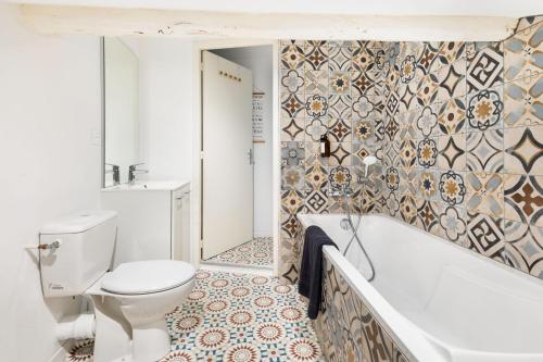 une salle de bain avec toilettes, baignoire et lavabo dans l'établissement Appartement sous combles - vieille batisse proche centre ville, à Saint-Galmier
