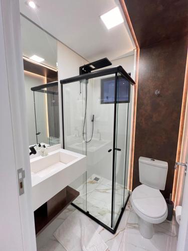 a bathroom with a shower and a sink and a toilet at Apto compacto, novo e moderno in Foz do Iguaçu