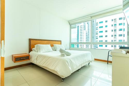 a bedroom with a bed and a large window at |Ahead| Lindo 2BR @Castillogrande cerca a la playa in Cartagena de Indias