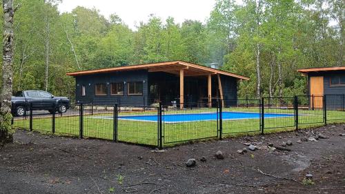 una casa con piscina delante de ella en Cabaña pilina, en Pucón