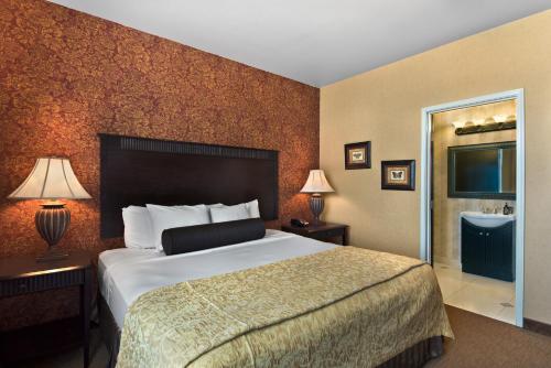 a hotel room with a bed and a bathroom at Oxford Suites Boise in Boise