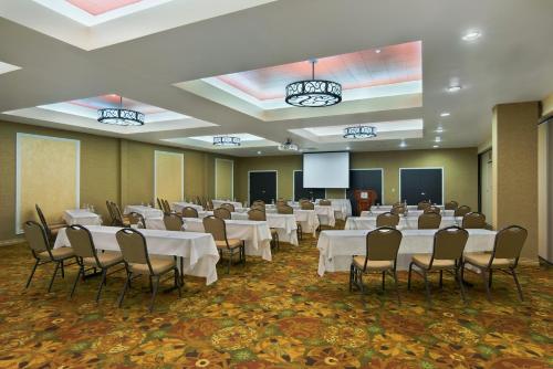 a conference room with tables and chairs and a screen at Oxford Suites Boise in Boise