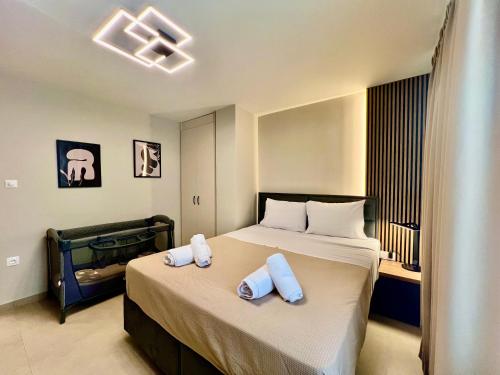 a bedroom with a bed with two towels on it at Douloudis Luxury Apartment in Alexandroupoli