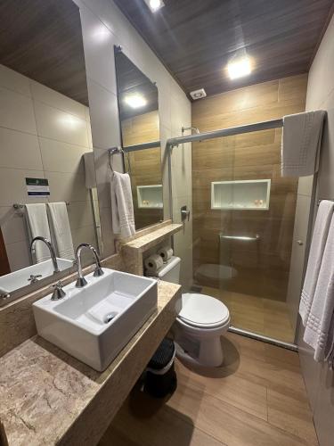 a bathroom with a sink and a toilet and a shower at Hotel Fazenda Vilarejo All Inclusive in Conservatória
