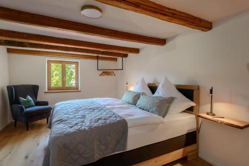 a bedroom with a bed with a chair and a window at am Egg in Rettenberg