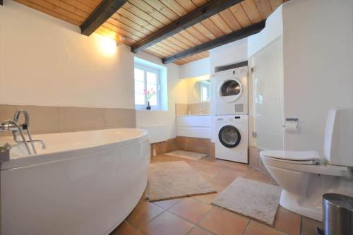 a bathroom with a tub and a washing machine at 10752-Ulfborg-Graevlingevej-14 in Øhuse