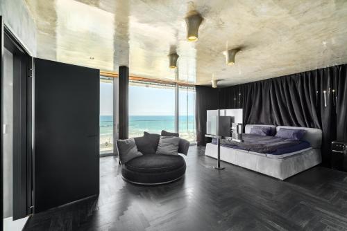 Una sala de estar con una cama, un sofá y un televisor. en Hayarkon Beach-Front Apartments, en Tel Aviv