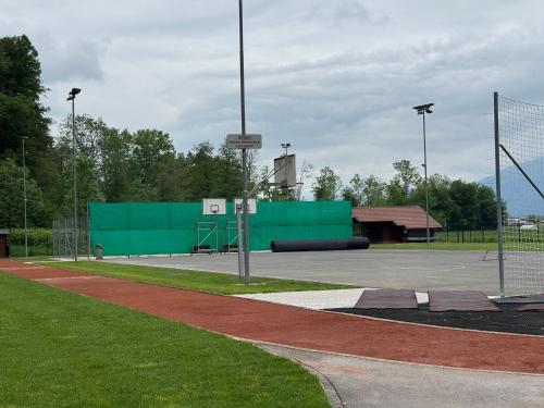 a basketball court with a green wall in a parking lot at Mojca's nest apartment in Mengeš