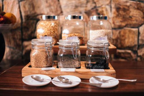 a wooden cutting board with jars of seeds and spoons at Hilton Garden Inn Praia Brava in Itajaí