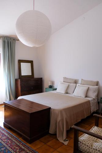 a bedroom with a large bed and a large pendant light at B&B Orto di Borghi in Faenza
