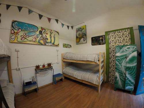 a room with two bunk beds and paintings on the wall at Art Hostel Casa Chaman in Valparaíso