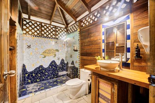 a bathroom with a toilet and a sink and a shower at Cariblue Beach and Jungle Resort in Puerto Viejo