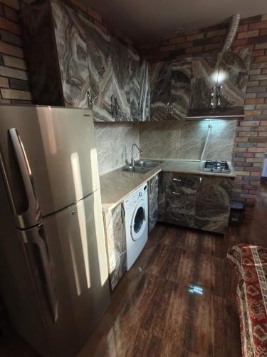 a kitchen with a refrigerator and a washing machine at частный дом, с двором in Vanadzor