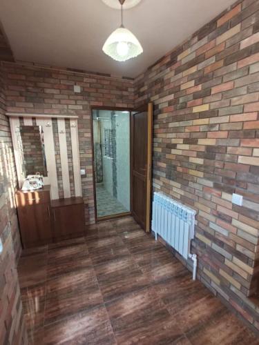 a bathroom with a brick wall and a mirror at частный дом, с двором in Vanadzor