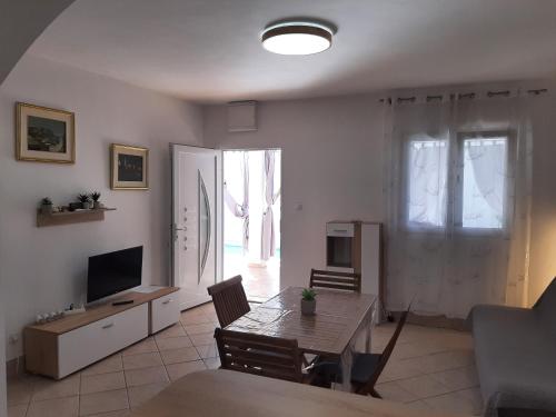 a living room with a table and a television at SEA YA - two apartments house with heated pool - 150m from beach in Zaglavice
