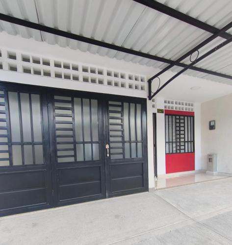 a garage with black doors and a red door at Casa del Sol in Mariquita