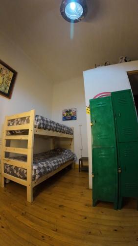 a room with two bunk beds and a green door at Art Hostel Casa Chaman in Valparaíso