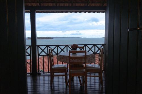 a table and chairs on a balcony with a view of the ocean at Casa em Búzios com vista espetacular in Búzios