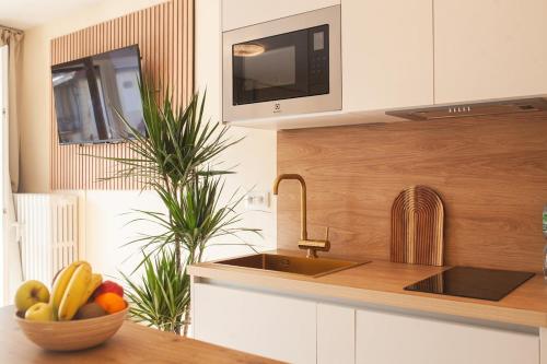 a kitchen with a bowl of fruit on a counter at Sofi Appart-Hôtel, balcon, parking privé in Metz