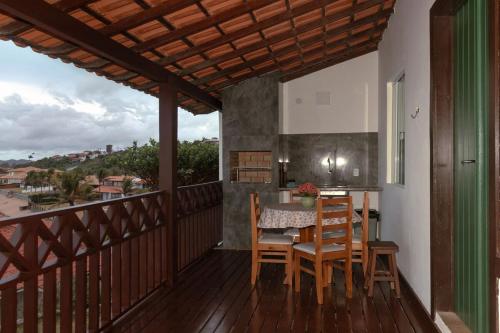 a wooden balcony with a table and chairs on it at Casa em Búzios com vista espetacular in Búzios