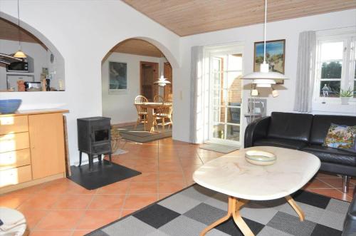 a living room with a black couch and a table at 20828-Ulfborg-Tyttebaervej-17 in Sundhuse