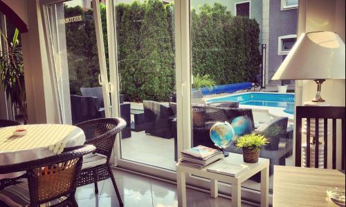 a patio with a table and chairs and a glass door at Vila DeLux in Negotin