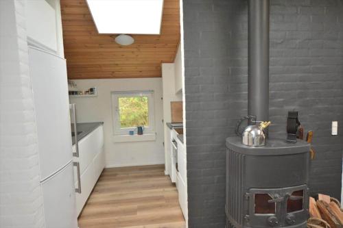 kuchnia z piecem opalanym drewnem w pokoju w obiekcie 40798-Ulfborg-Helmklit-324 w mieście Fjand Gårde