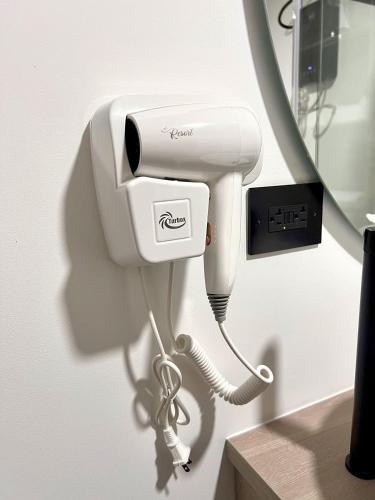 a white phone is hanging on a wall at BIT by Simple stay in Medellín